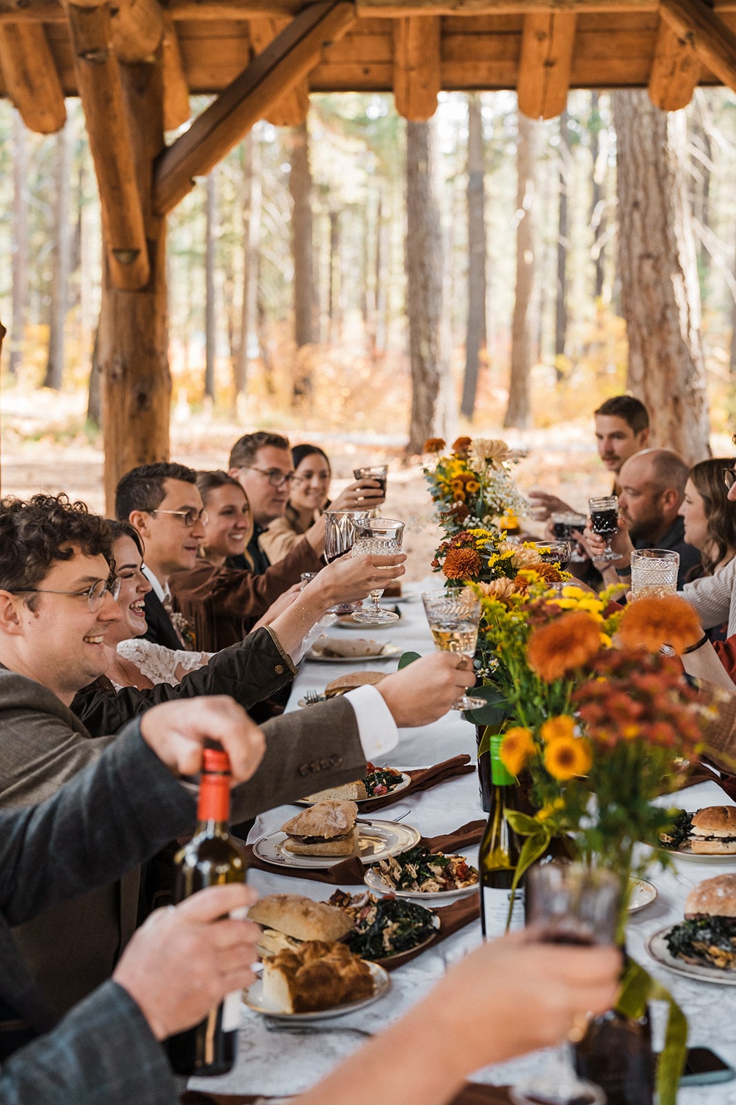 Guests toast at a shelter at Lake Wenatchee State Park - a wedding venue in Washington.