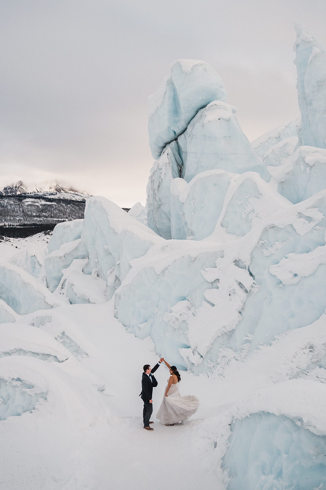 Bride and groom dance in the snow while eloping in Alaska. 