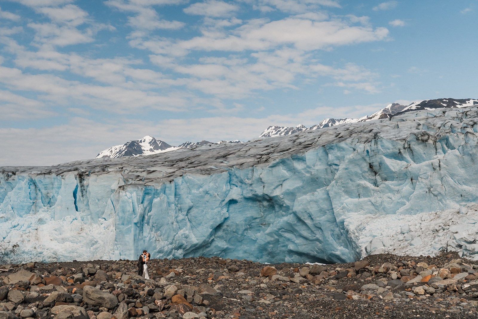 Bride and groom stand on a glacier and kiss during their Palmer, Alaska elopement.