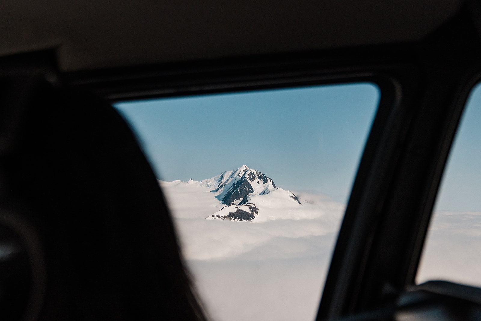 View of an Alaskan mountain peak from a helicopter window.