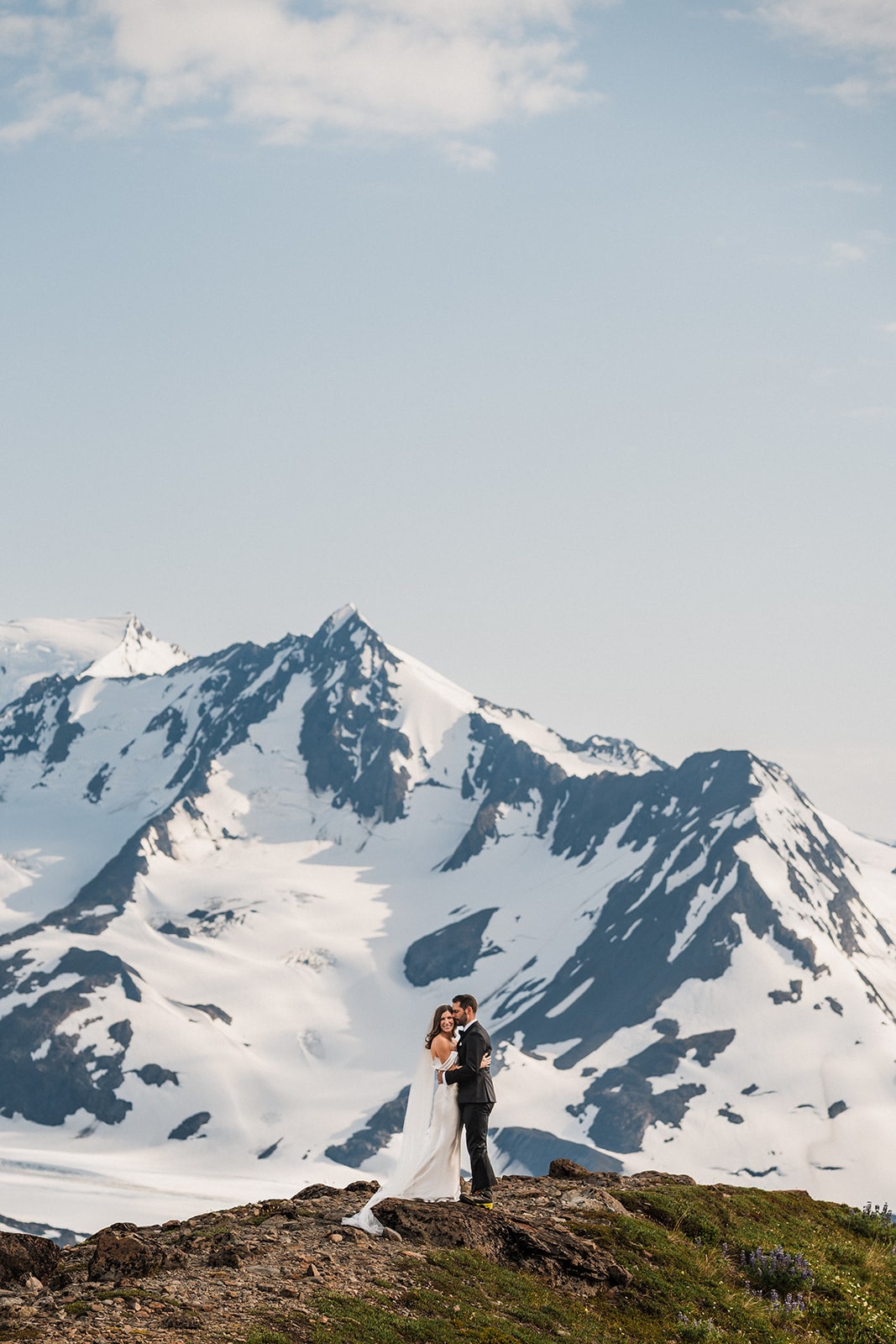 Groom kisses bride on a mountain trail during their five location elopement with Outbound Heli Adventures.