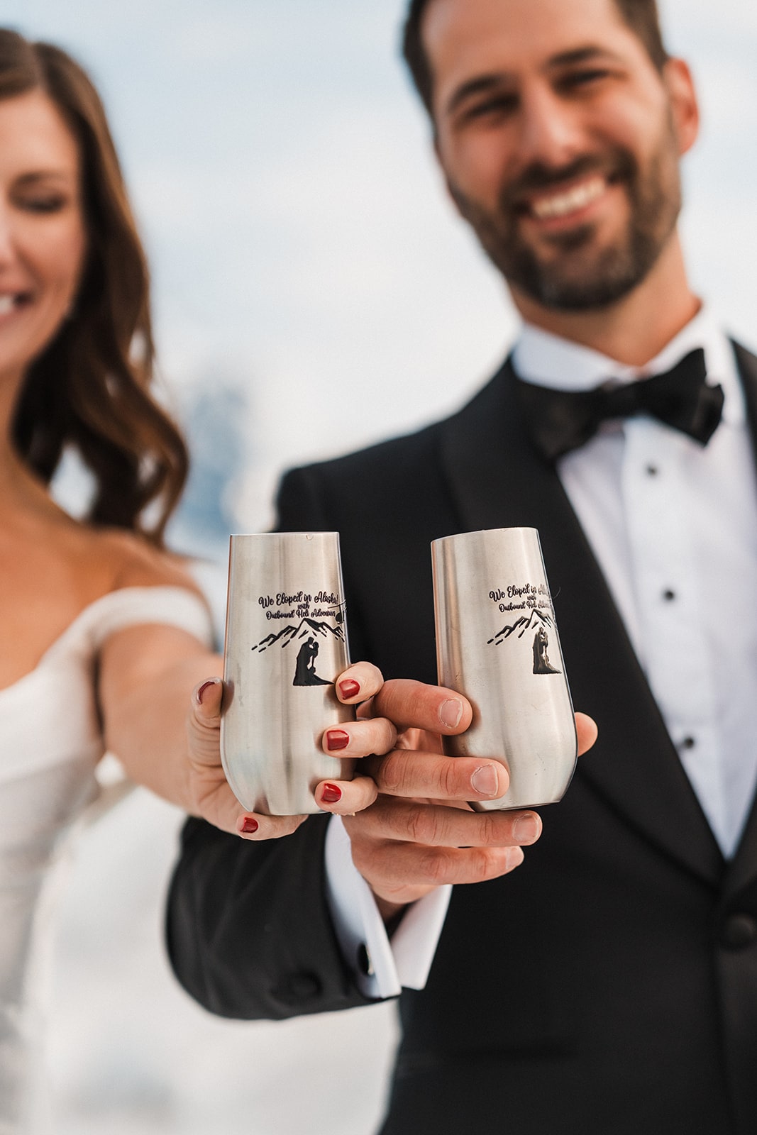 Bride and groom hold custom silver champagne chutes during their Palmer, Alaska elopement.