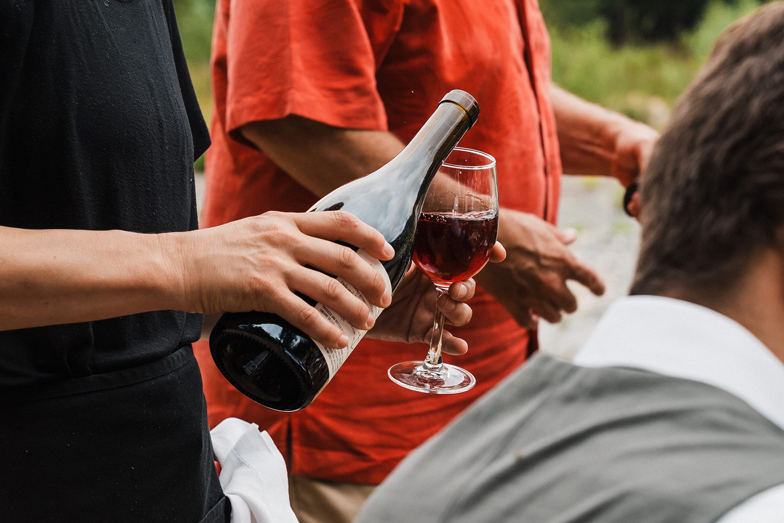 Private chef pours wine at a micro wedding reception in Washington state. 