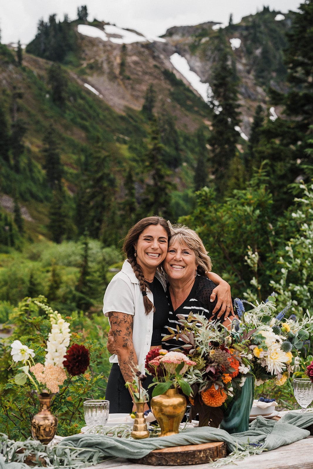 Bride hugs mother at her intimate wedding reception in the Washington mountains. 