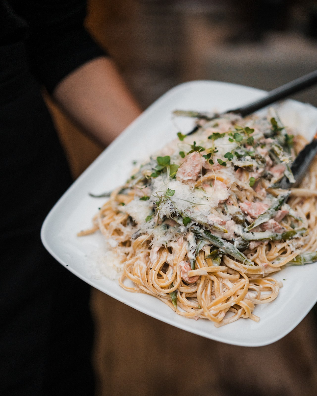 Private chef serves a pasta dish at a micro wedding reception. 