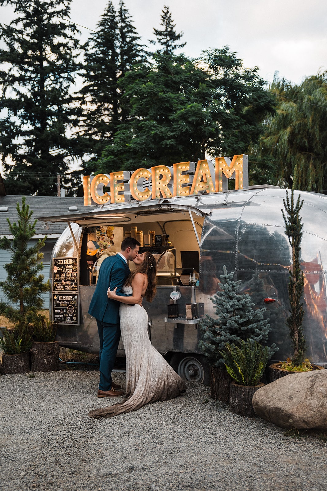 Bride and groom kiss next to an airstream ice cream truck at the end of their Washington micro wedding. 