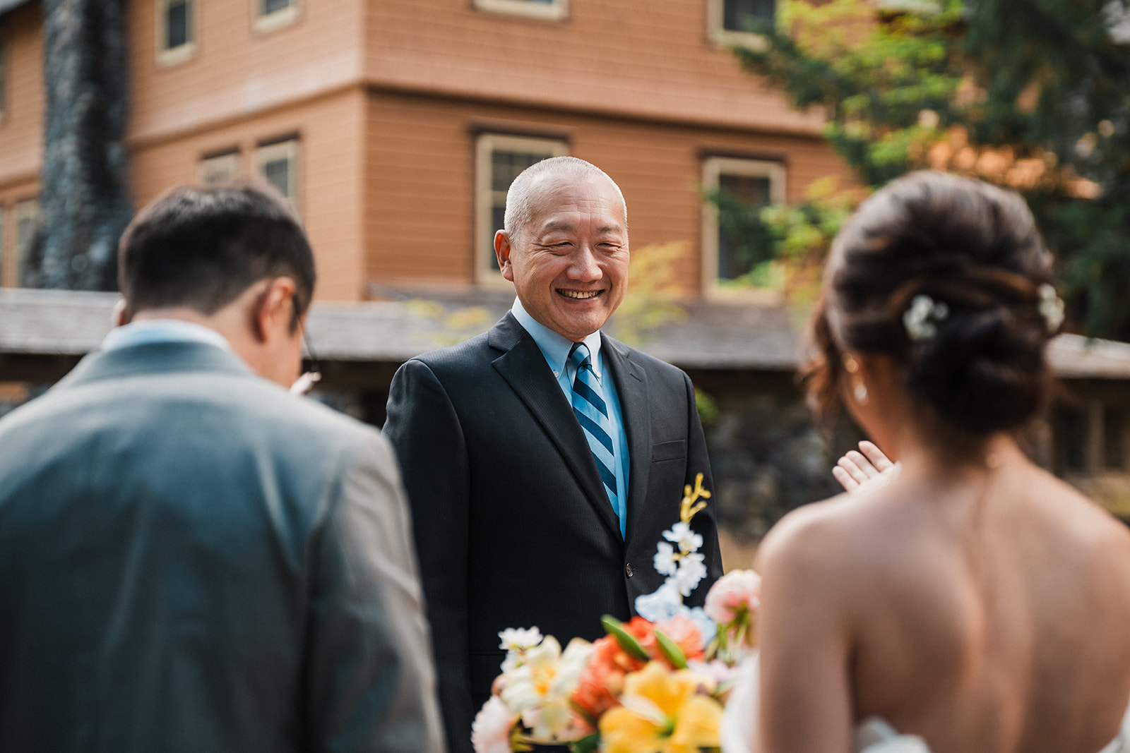 Father of the bride smiles when seeing her at her forest wedding in Washington. 