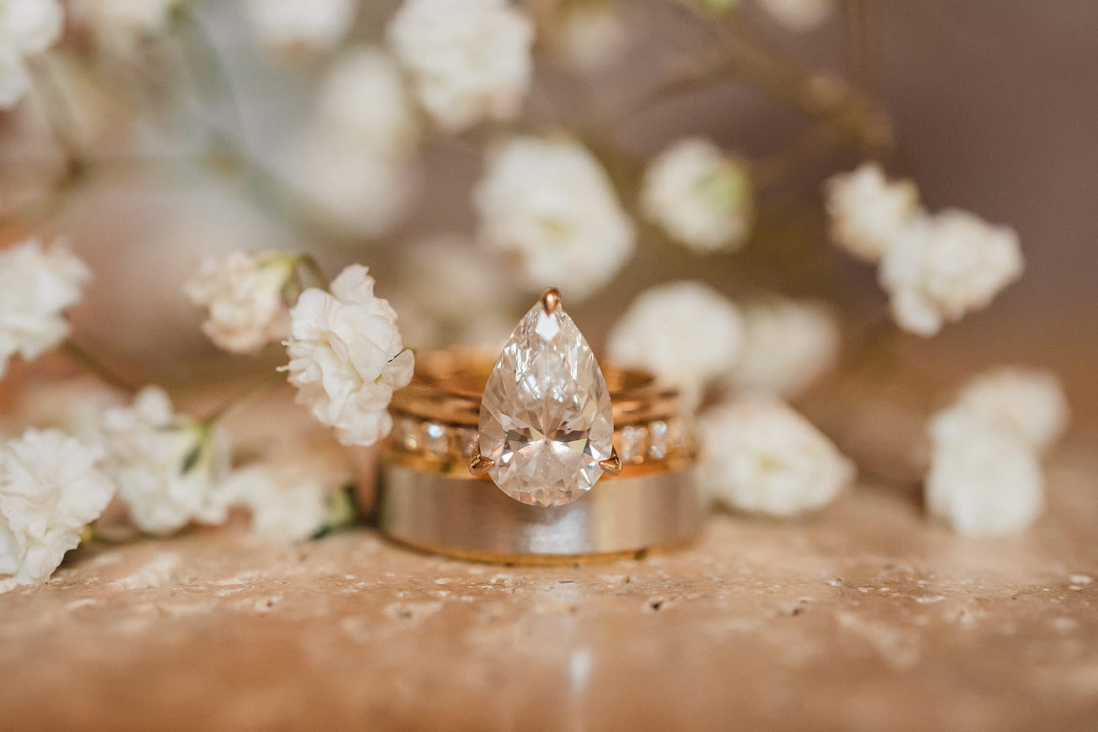 Gold wedding bands and white flowers. 