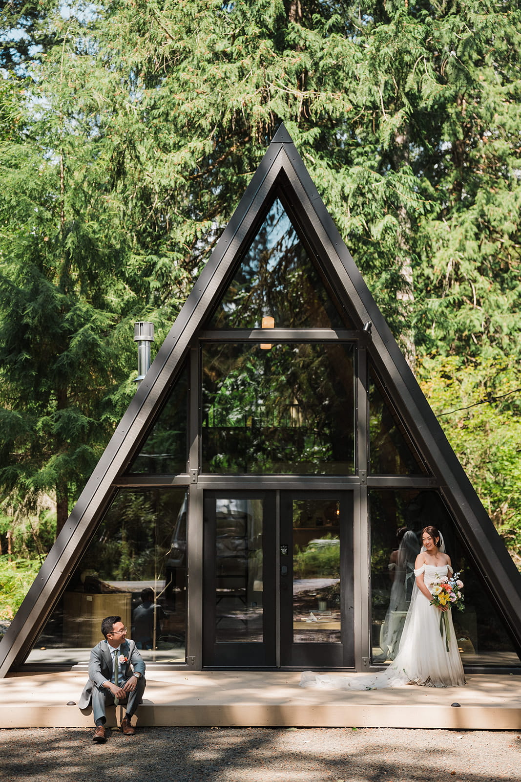 Bride and groom stand and sit on the porch of their a-frame cabin in Mt Rainier. 