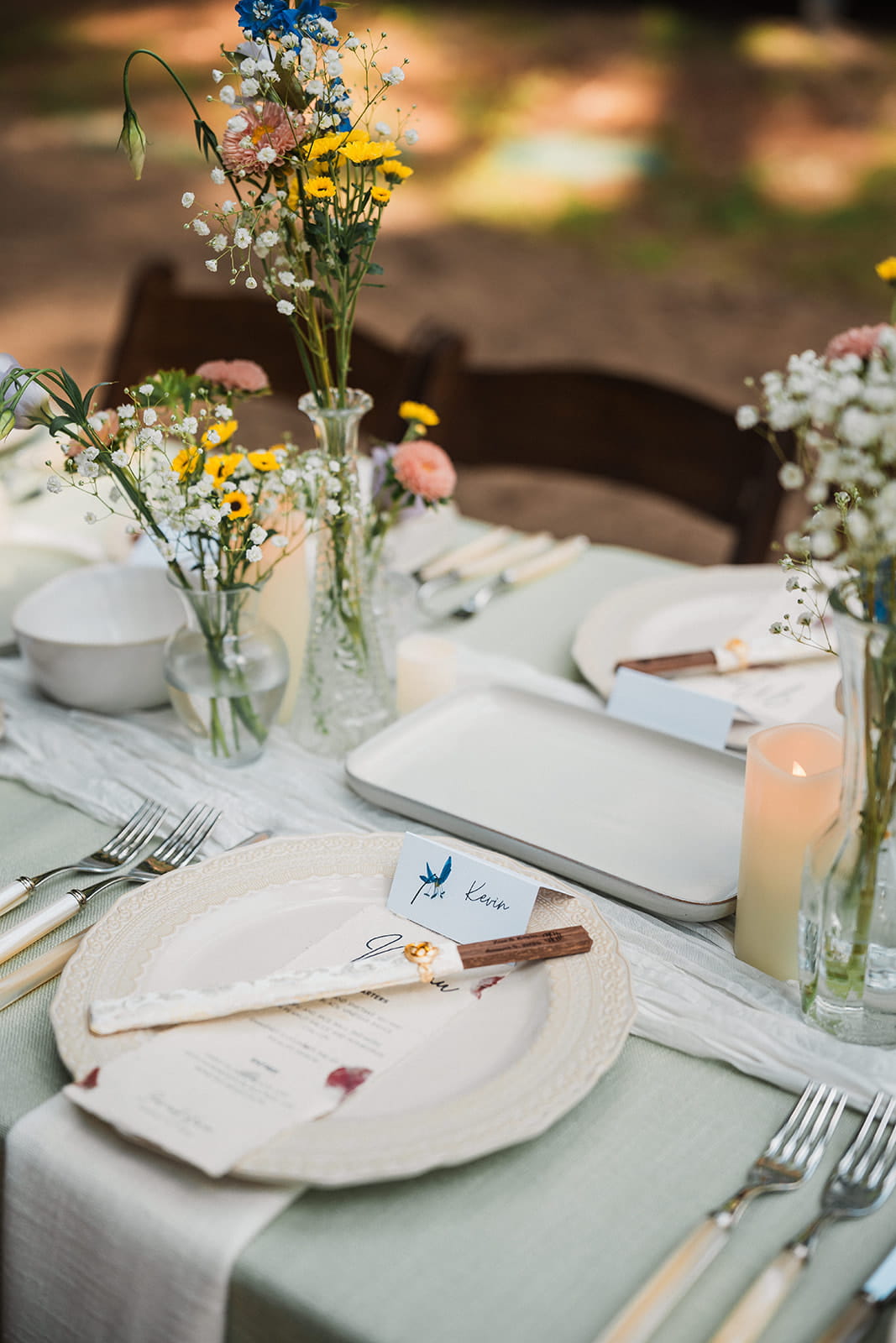 Sage green and wildflower themed forest wedding reception table decor.