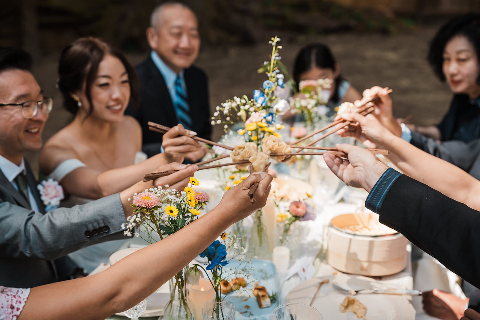 Guests toast dumplings during their forest wedding reception meal. 