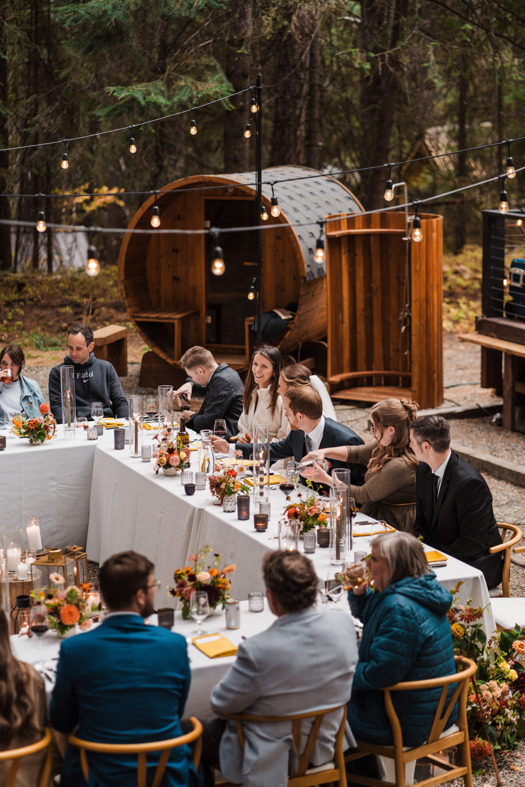 Guests sit around a square reception table setup at an A-frame cabin in Washington. 