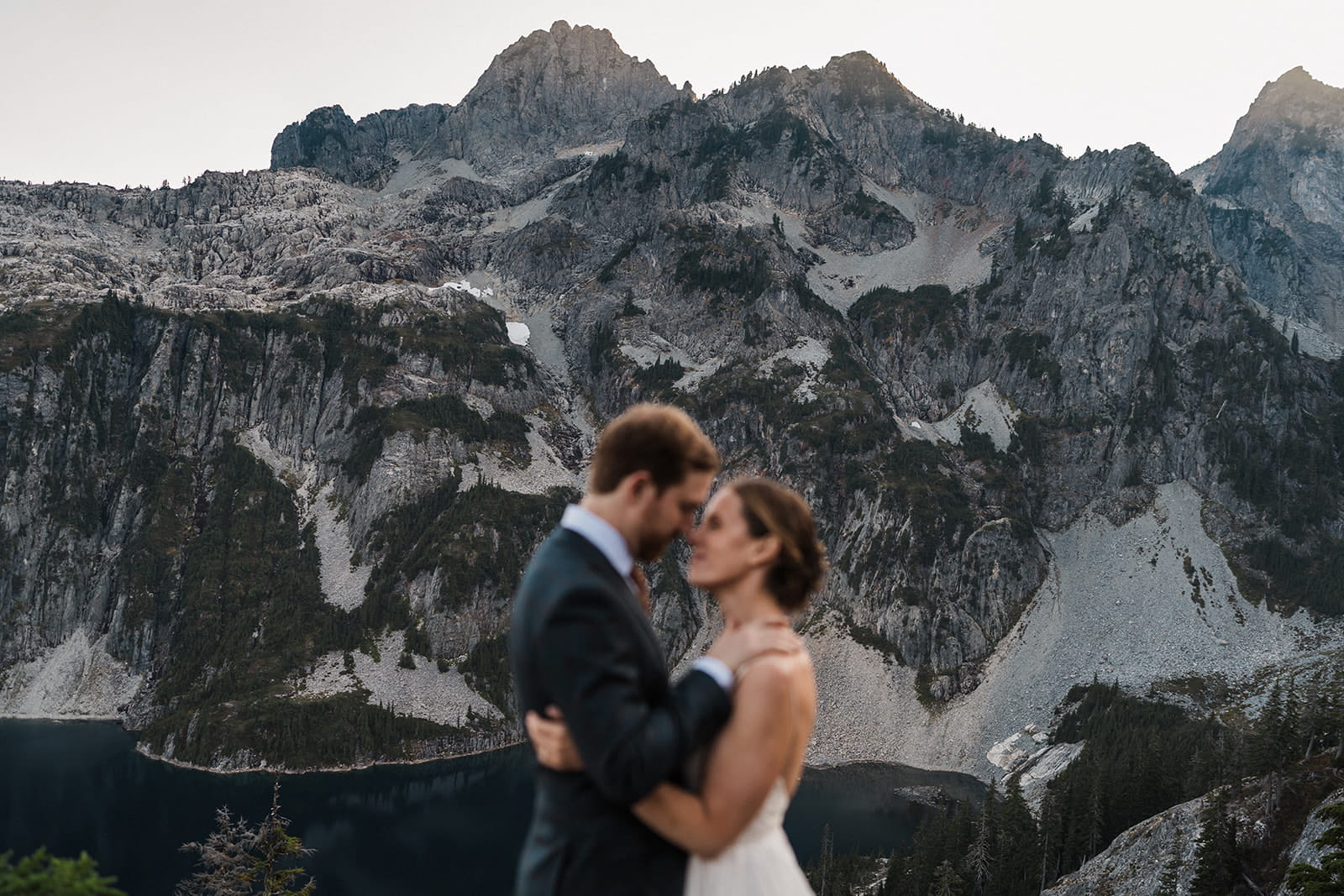 Newlyweds kiss on Snow Lake Trail during their backpacking elopement. 