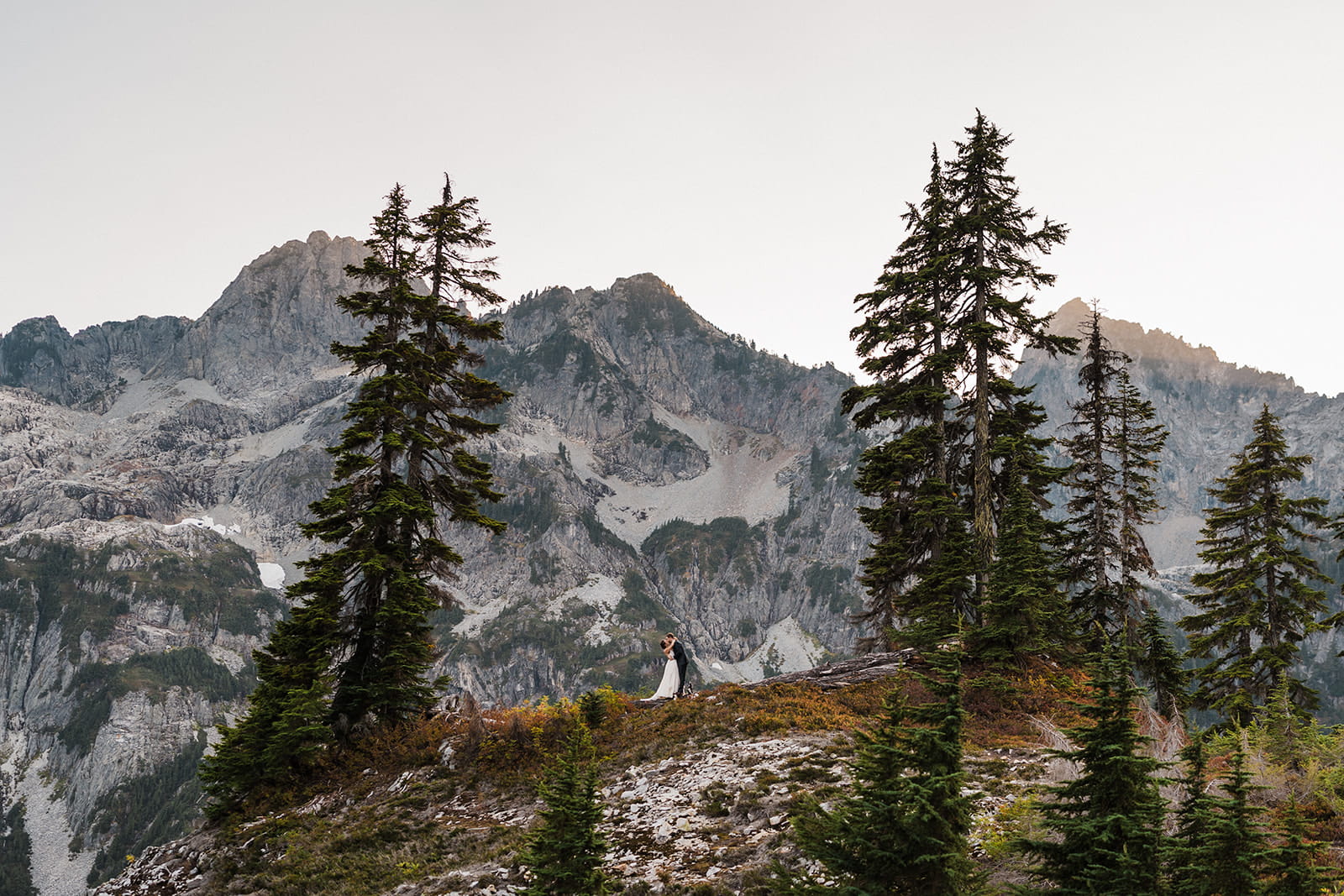 Couple stands on Snow Lake Trail in their elopement attire.