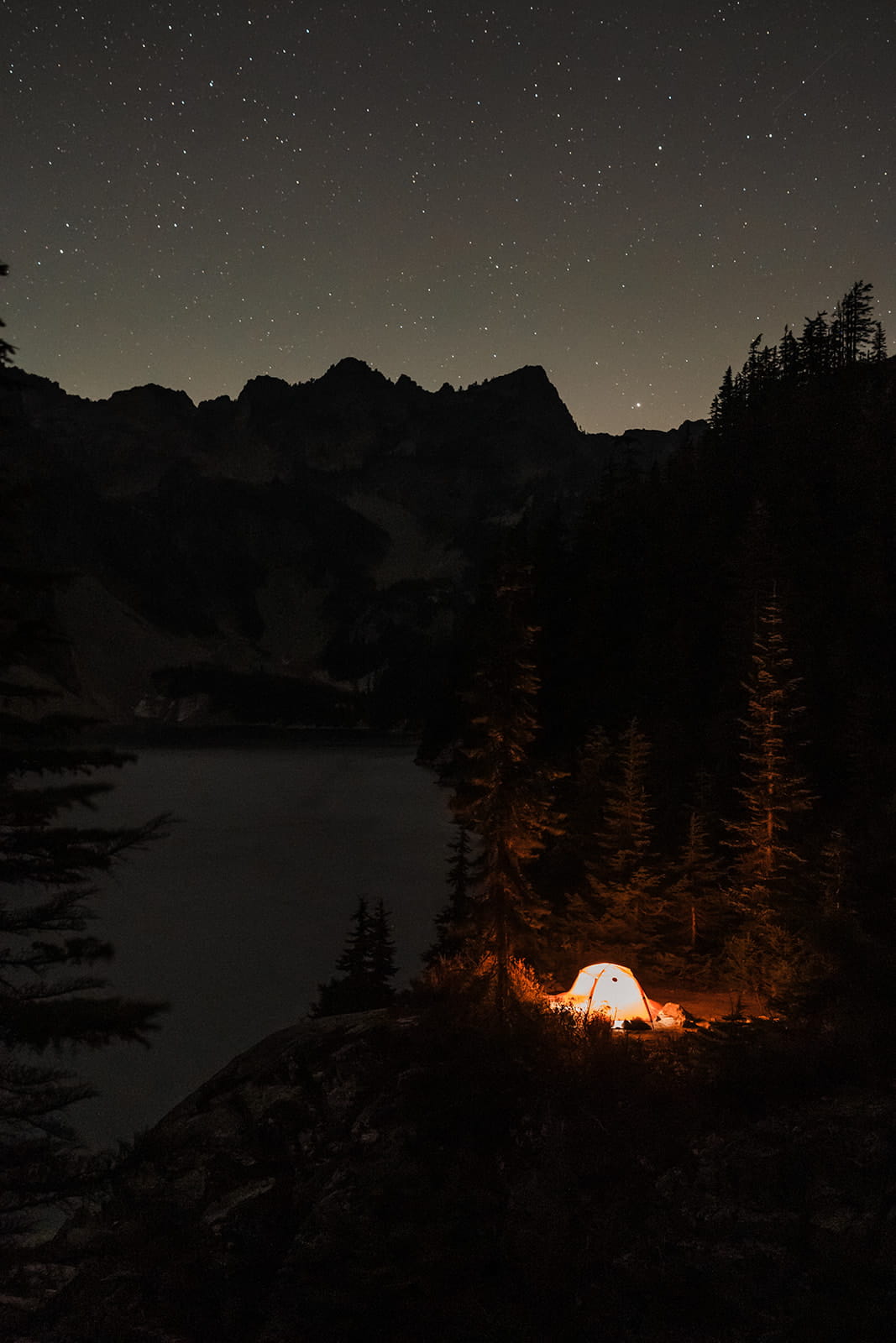 Camping tent lit by light during an overnight backpacking trip at Snow Lake. 