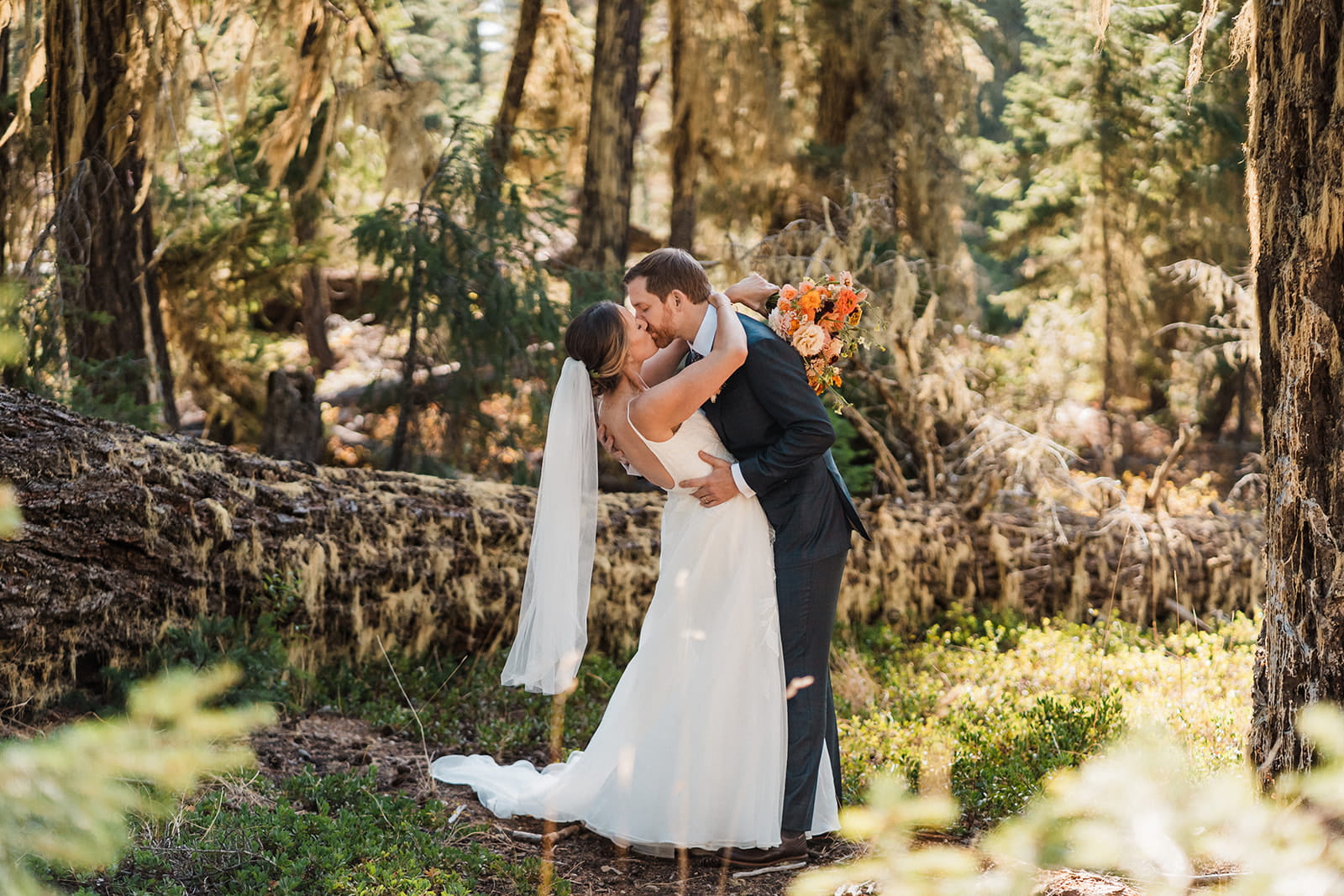 Newlyweds kiss during their forest elopement photos in Snoqualmie, Washington. 