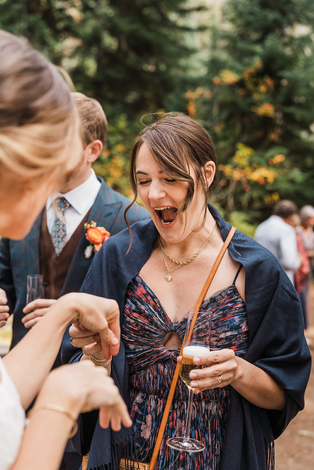 Guests reacts to seeing bride's wedding ring after her outdoor wedding ceremony.