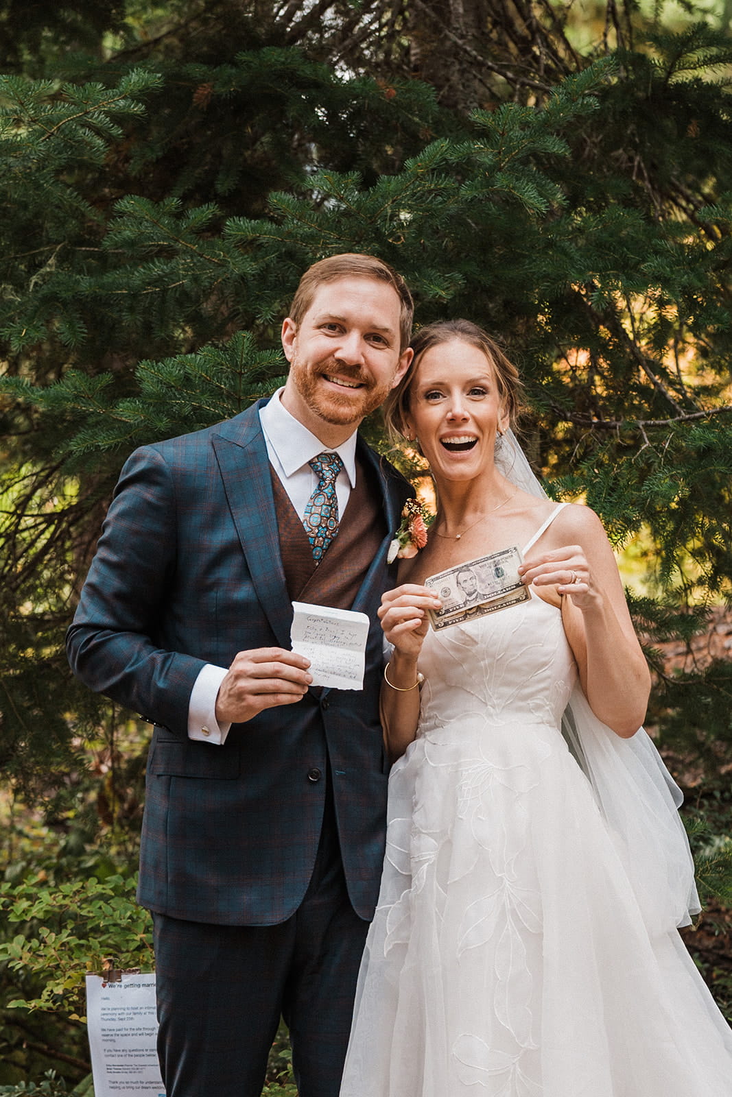 Newlyweds hold cash and letter at their wedding ceremony at Cooper Lake. 