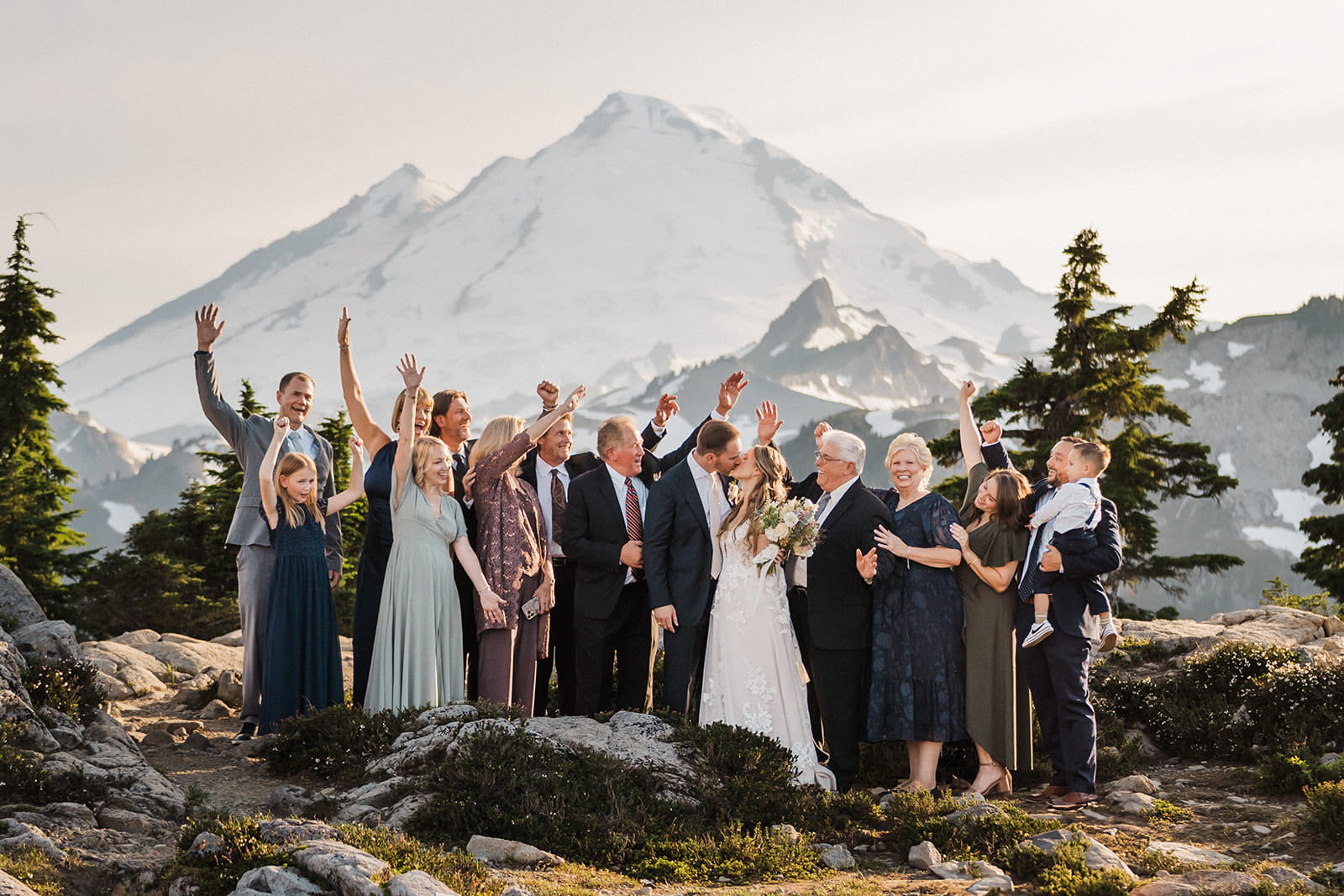 Guests cheer while newlyweds kiss after their intimate wedding ceremony in the North Cascades.