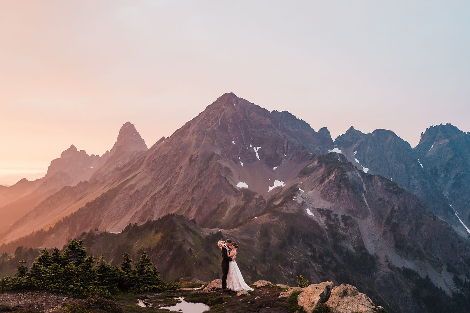 Newlyweds elope on a mountain trail at sunset during their intimate wedding in the North Cascades.