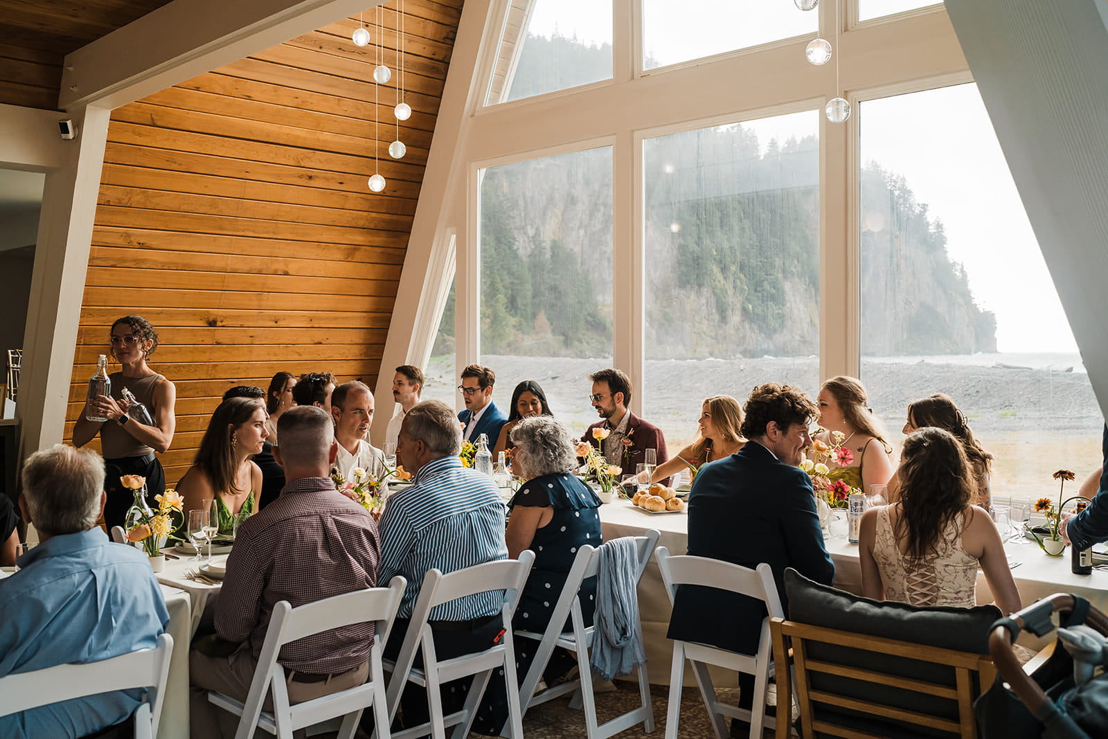 Guests eat in an a-frame cabin on the Olympic Peninsula during a micro wedding reception.
