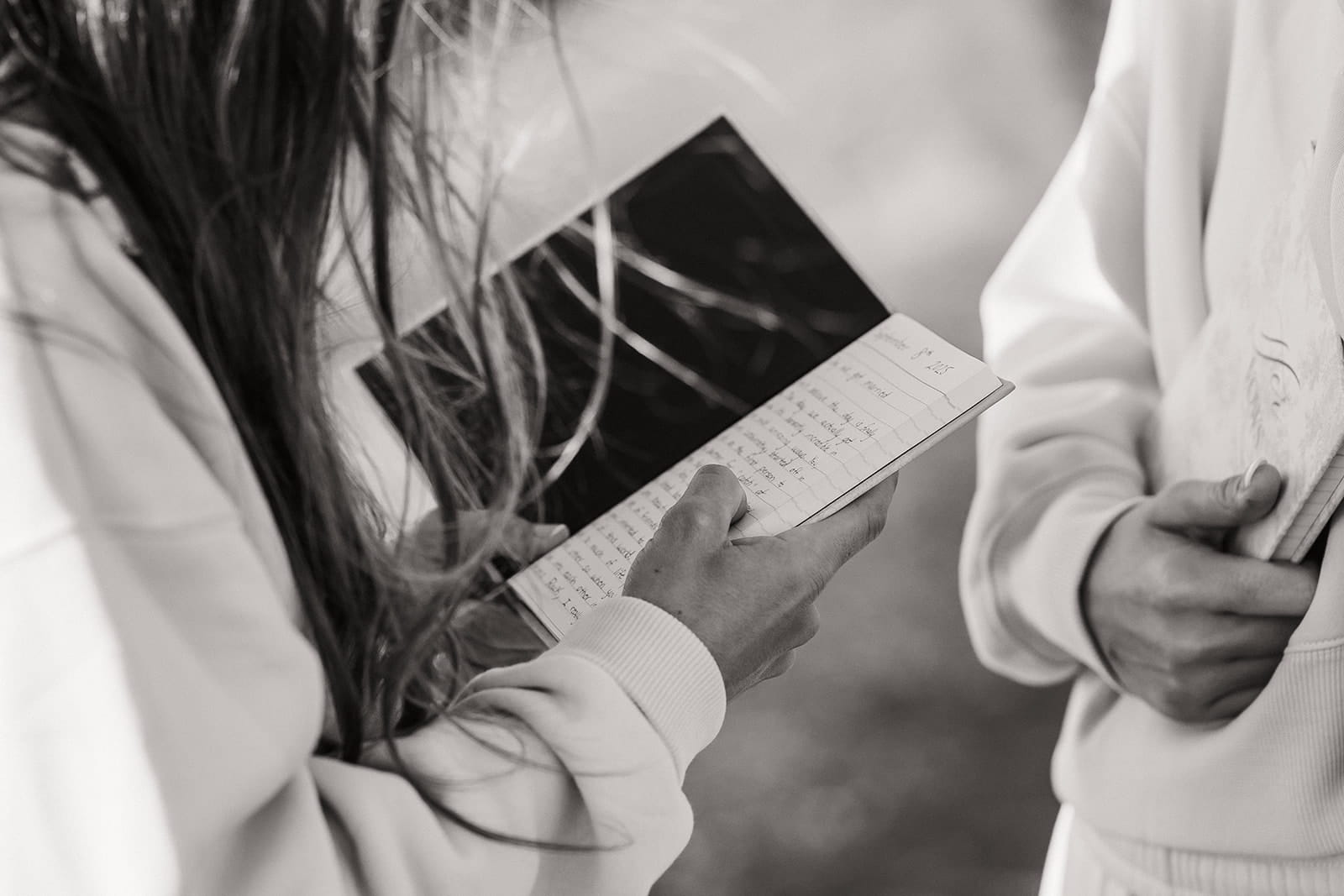 Woman holds vow book and reads private vows at sunrise on Hurricane Ridge.