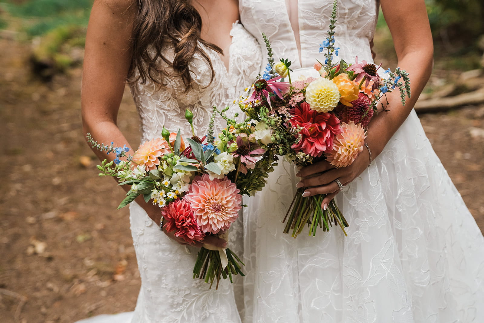 Two brides hold wildflower bouquets.