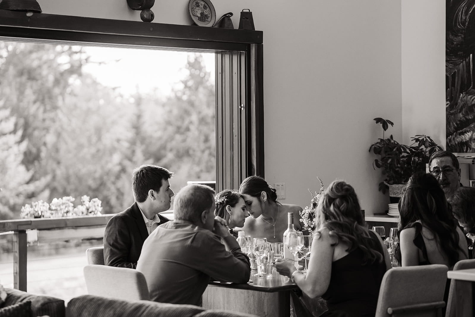 Brides share a moment while dining with their guests at their Port Angeles wedding reception. 