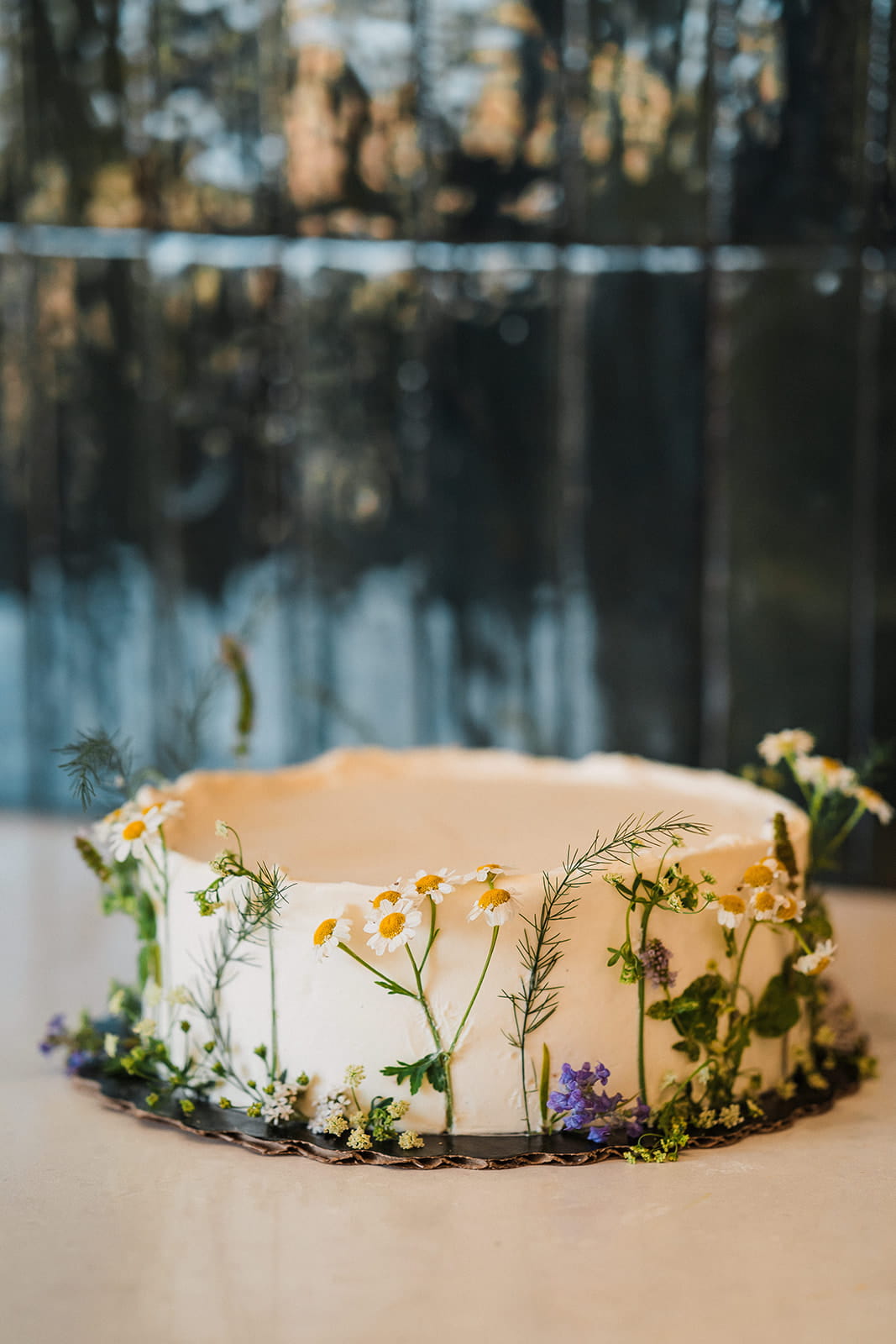 White single tier wedding cake decorated with wildflowers.