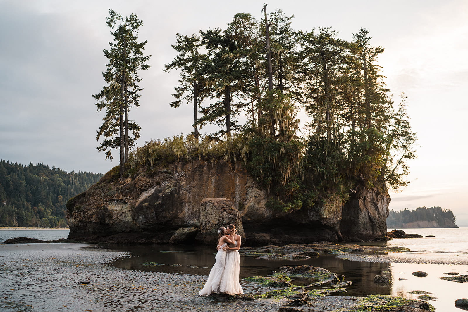 Two brides hug during their Port Angeles beach wedding on the Olympic Coast.