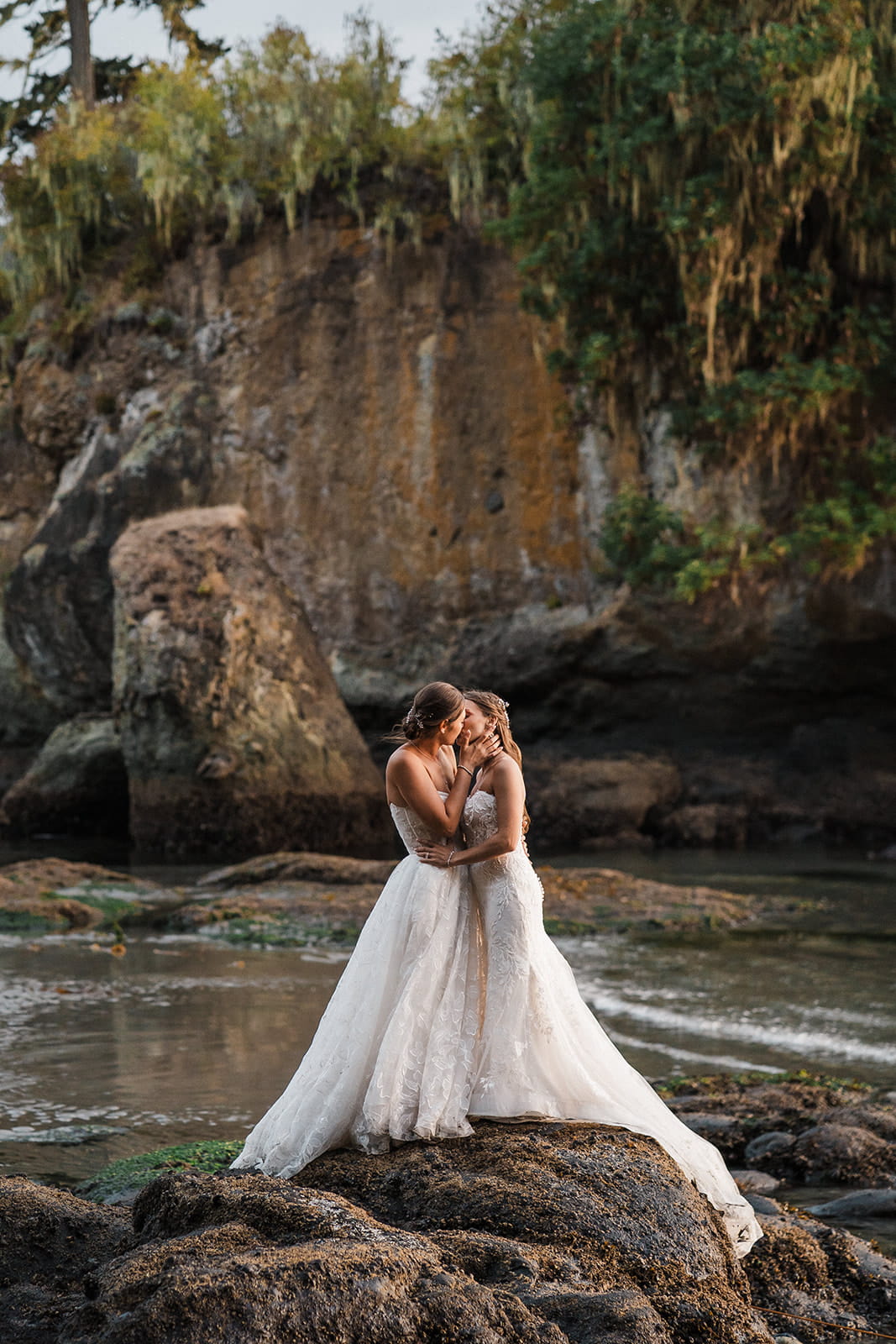 Brides kiss on a beach in Port Angeles during their adventure wedding.