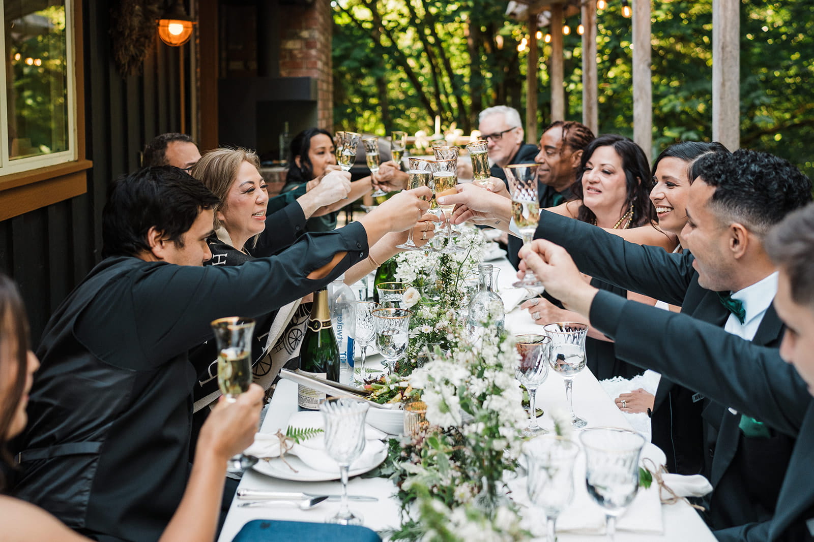 Guests raise glasses for a toast at an intimate wedding reception at an Airbnb. 